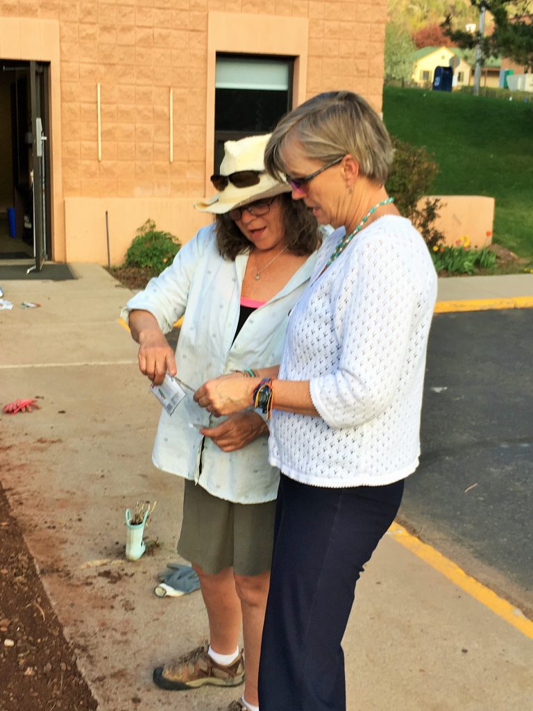 Two women discuss what type of seeds should go into a garden.