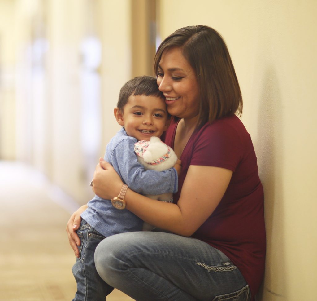 A parent hugs a smiling child.